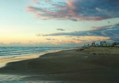 south padre island beach and shoreline with buildings in background